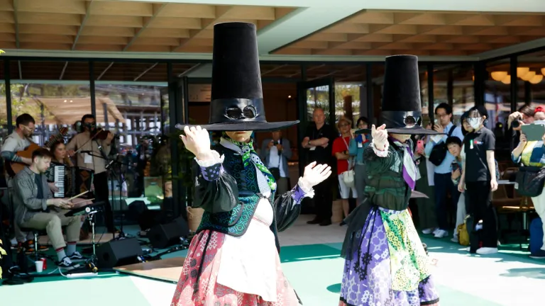 Dancers in traditional Welsh dress with large oversized hats, in mid-performance