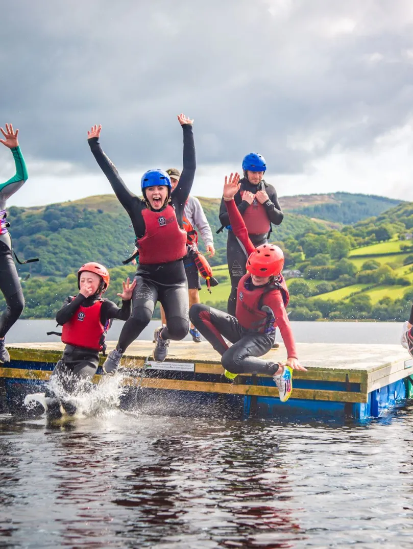 Children jumping off a float in the water.
