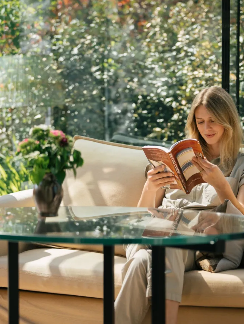 A person sitting on a sofa reading a book.