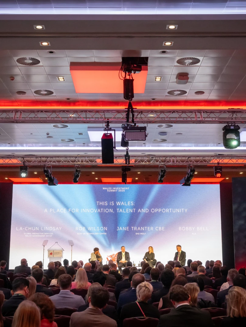 A panel of business people and professionals sitting on a stage in front of a large audience