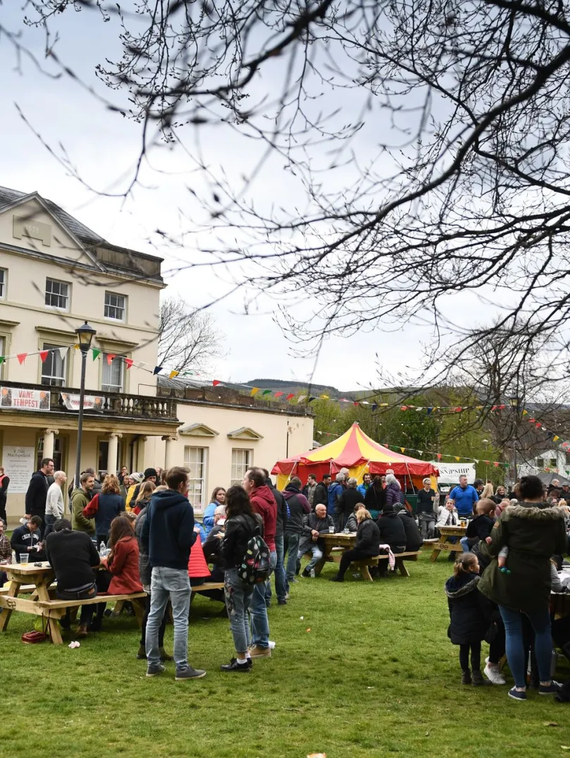 Crowds of people standing outside a large white building at the festival.
