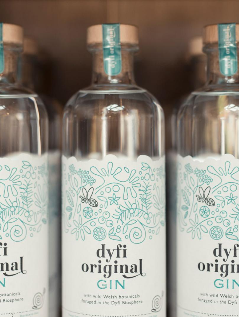 Dyfi original gin bottles lined up on shelf