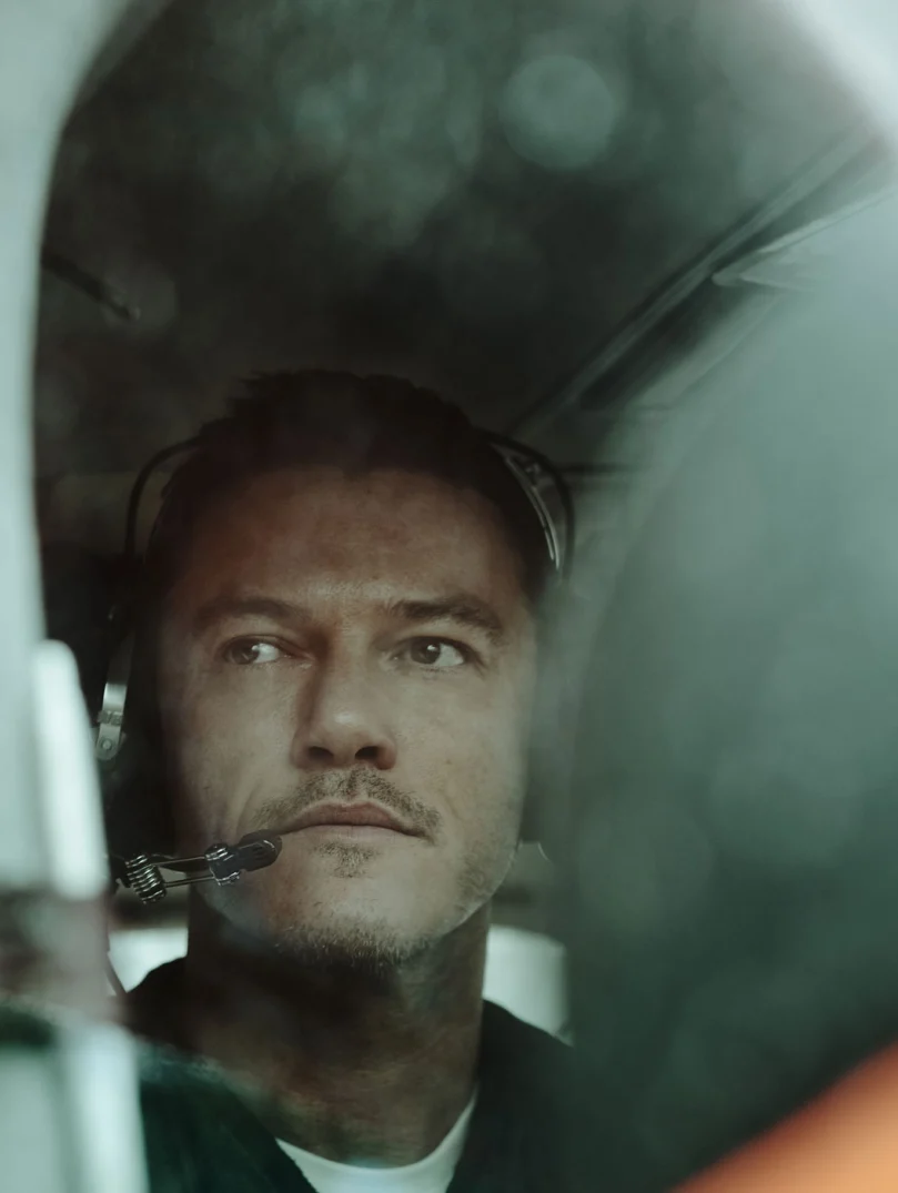 Luke Evans en pequeño avión con auriculares, listo para despegar