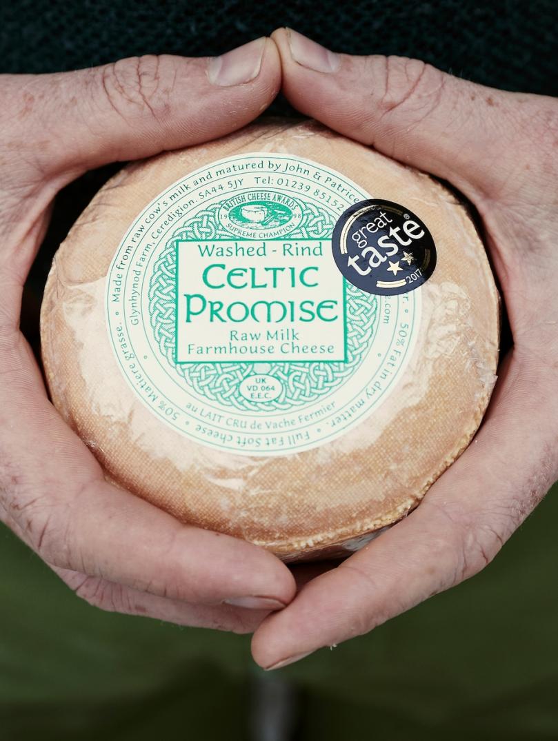 Primer plano de manos sosteniendo queso celta promesa.