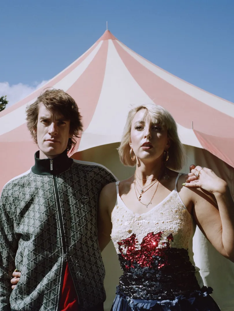 Two people standing in front of a tent.