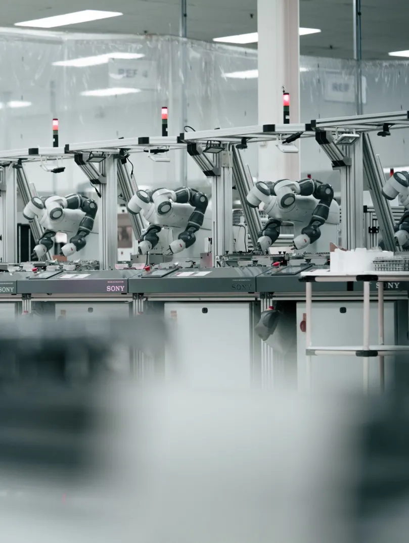 Robots alineados a lo largo de un banco de trabajo en un entorno técnico de fábrica impecable.