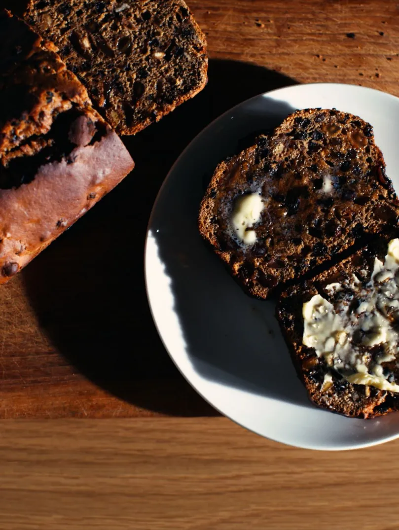 A loaf of Welsh bara brith fruit, with some delicious looking slices presented on a plate