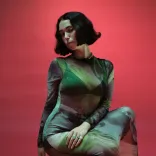 A woman in a green dress facing the camera