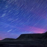 A dark night sky with stars showing brightly