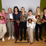 Group of women holding the caps.