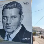 A large painting of Richard Burton on a wall.