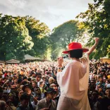 A singer on a stage in front of a crowd of people.