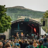 A band performing at the Green Man Festival with a crowd looking on.