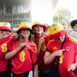 Wales supporters wearing Cymru shirts and bucket hats in a UEFA Women's EURO 2025 fan zone. 