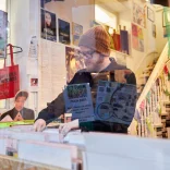 Huw Stephens mirando a través de los registros en Spillers, las arcadas victorianas de Cardiff