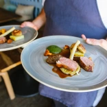Un chef que lleva dos platos de comida.