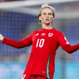 Vestida con su camiseta roja de fútbol con el número 10, Fishlock está de pie con los brazos extendidos a los lados y una expresión de duda en el rostro.