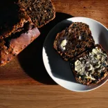 A loaf of Welsh bara brith fruit, with some delicious looking slices presented on a plate