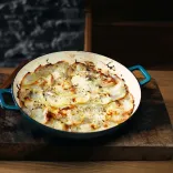 A beautifully presented cast iron pan with a freshly cooked Welsh onion cake