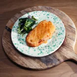 A beautifully presented plate of Welsh rarebit (toasted bread with a cheese mix), with salad, presented on a wooden platter